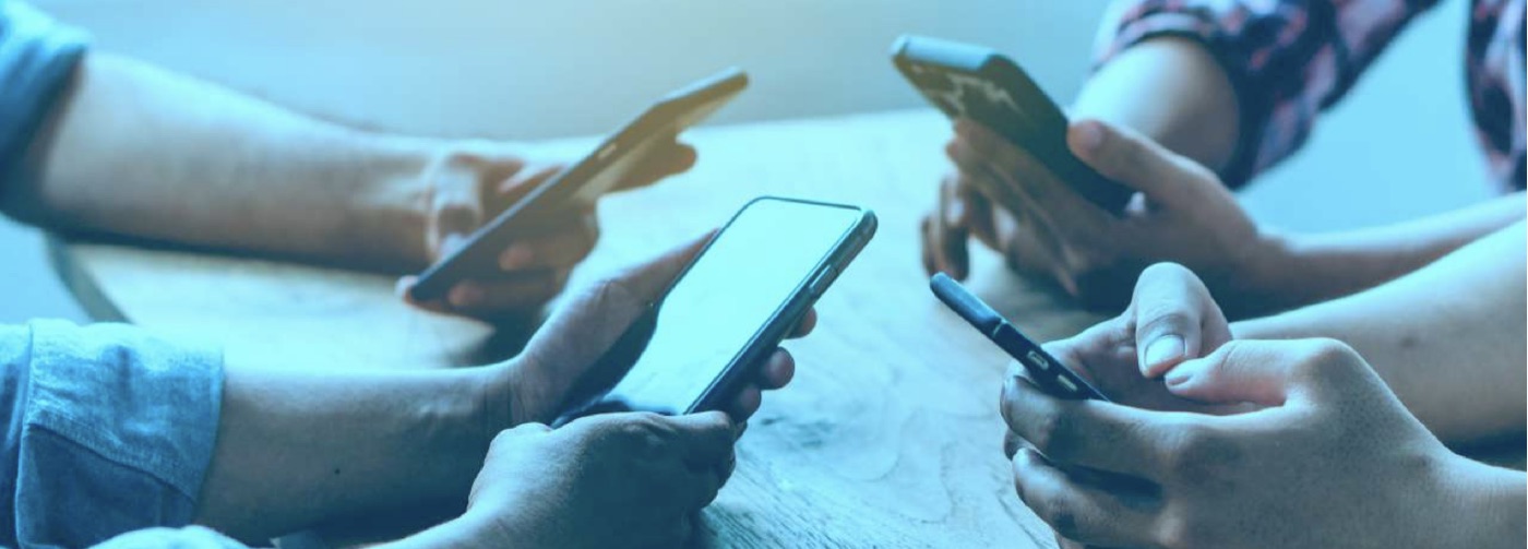 Several people holding smartphones around a table