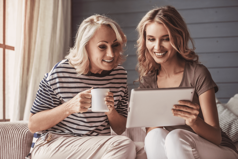 woman showing to another woman something interesting in her tablet