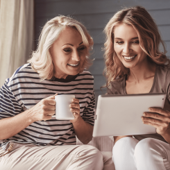 woman showing to another woman something interesting in her tablet